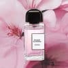 Bouquet de Hongrie Eau de Parfum by BDK Parfums bottle displayed in front of oversized soft pink flowers, highlighting the fragrance’s feminine floral aesthetic.