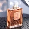 Luxury CHANEL COCO MADEMOISELLE Eau de Parfum Intense perfume bottle displayed on a textured black surface with soft lighting and reflective glass details.