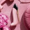 Good Girl Blush Eau de Parfum pink stiletto bottle on soft pink background with flowers and retro telephone styling