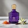 Creed Queen of Silk Eau de Parfum purple bottle styled with saffron threads, vanilla bean, and white florals on a marble surface showcasing the fragrance inspiration notes.