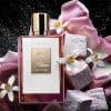 Love, Don’t Be Shy by Kilian Paris surrounded by marshmallows, pink rose petals, and orange blossom flowers