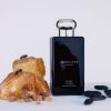 Jo Malone Myrrh & Tonka Cologne bottle with spices and coffee beans.