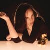 Billie Eilish with perfume bottle for stylish scent branding.